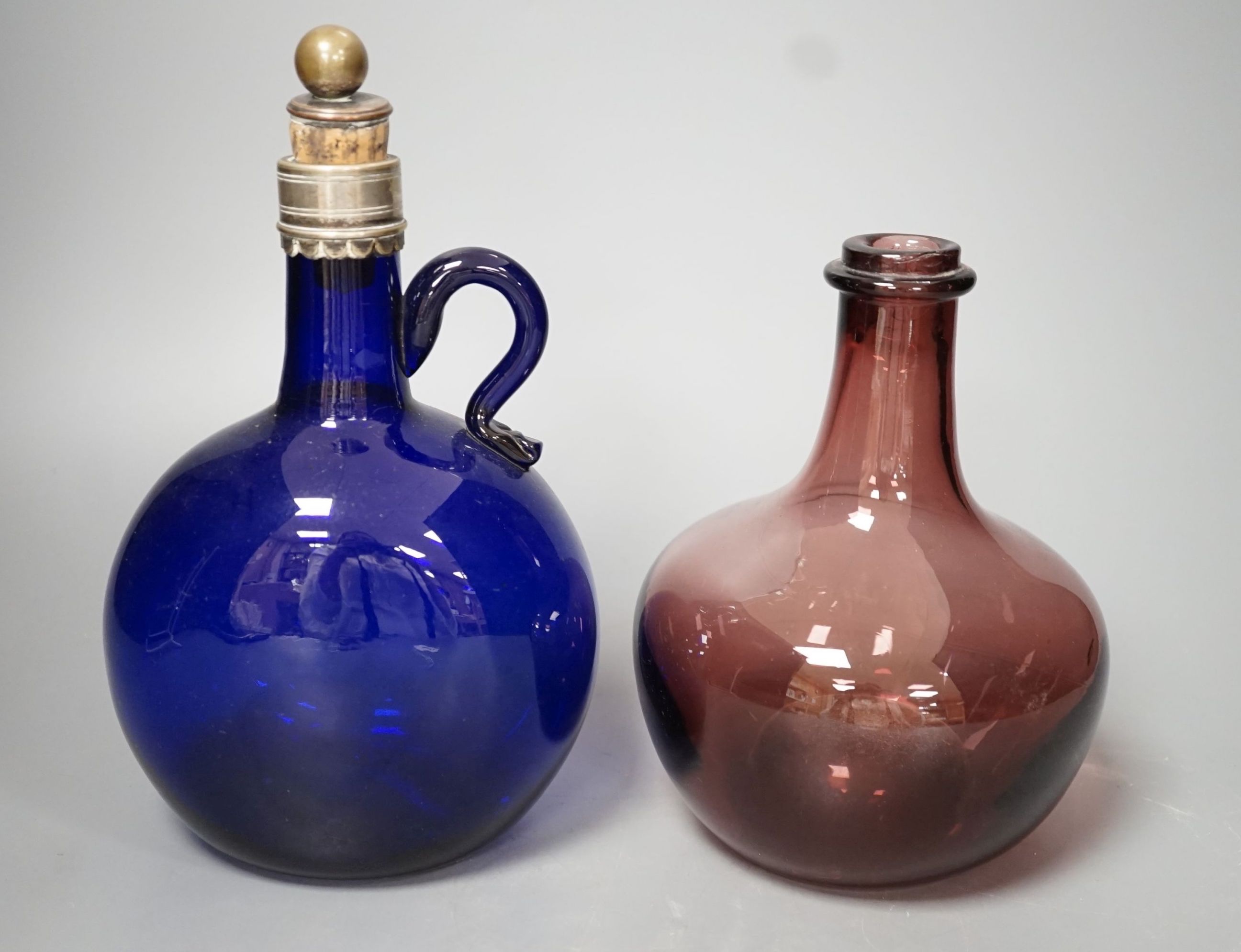 A Victorian blue glass claret jug and an amethyst glass bottle, tallest 23cm